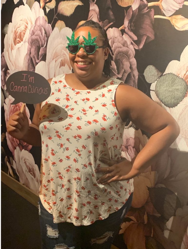 Image of Karlene holding a sign that says I'm CannaCuriou